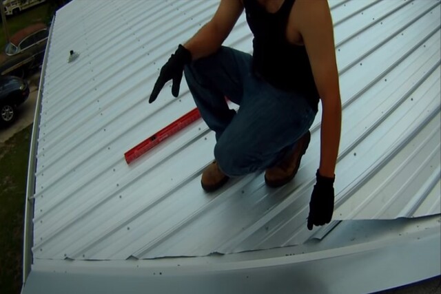 Costa Mesa Roofing worker on metal roof over shingles